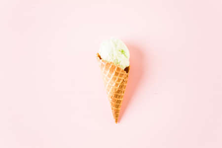 Waffle ice cream cones with plate of ice cream scoops on a pink background.の写真素材