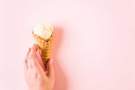 Waffle ice cream cones with plate of ice cream scoops on a pink background.の写真素材