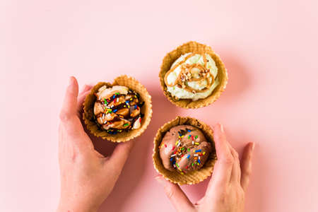 Waffle ice cream bowls with scoops of ice cream on a pink background.の写真素材