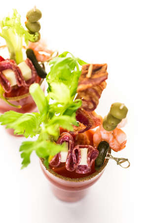 Bloody mary cocktail garnished with celery sticks, olives, and bacon strips.の写真素材