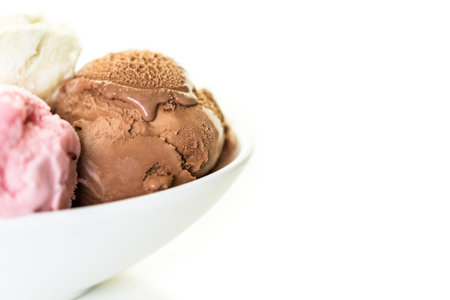 Variety of ice cream scoops in a white bowl.