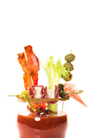 Bloody mary cocktail garnished with celery sticks, olives, and bacon strips.の写真素材