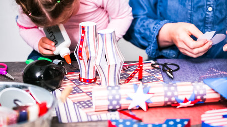 Step by step. Mother and daughter making paper firecrackers for July 4th celebration.