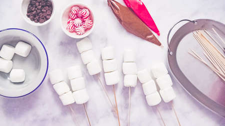 Step by step. Flat lay. Making marshmallow snowman and reindeer on sticks hot chocolate toppers for food gifting.の写真素材