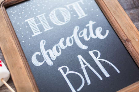 Chalk board with sign for hot chocolate bar with variety of topppings.の写真素材