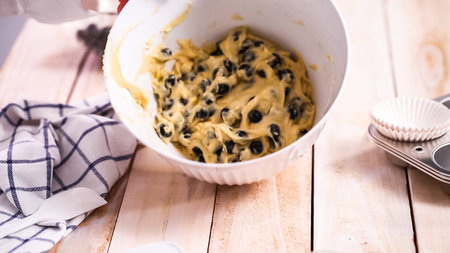 Mixing ingredients together in mixing bowl for blueberry muffins.