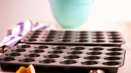 Lining cupcake pan with paper cupcake liners.