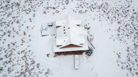 Aerial view of the mountain house covered in snow in the Winter.の写真素材