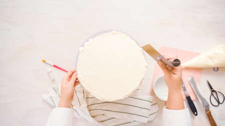Flat lay. Frosting pink and purple cake with a white buttercream icing.の写真素材