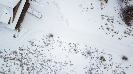 Aerial view of the mountain house covered in snow in the Winter.
