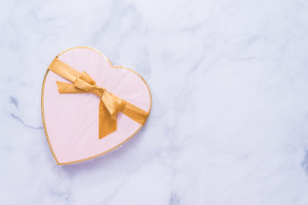 Flat lay. Heart chape box with pink chocolates.