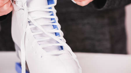 Lacing new white figure skates with white laces.の写真素材