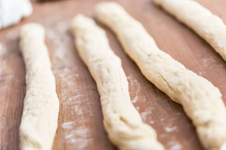 Rolling dough on the wood table to make challah bread.の写真素材