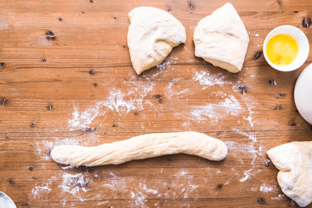 Flat lay. Rolling dough on the wood table to make challah bread.