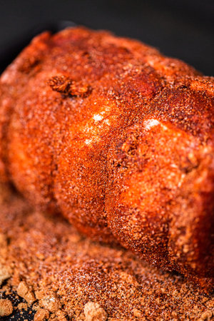 Close up view. Uncooked boneless pork roast seasoned with spices on baking sheet.