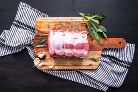 Flat lay. Uncooked boneless pork roast on the cutting board.の写真素材