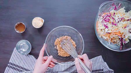 Flat lay. Step by step. Preparing homemade coleslaw in gass mixing bowl.の写真素材