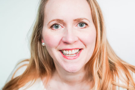 Studio portrait of smiling middle aged woman.