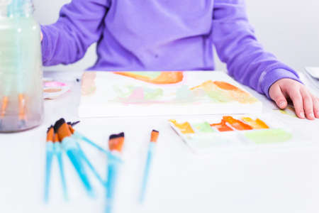 Little girl painting on canvas with arcylic paint.の写真素材