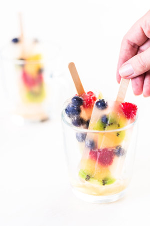 Homemade fresh fruit popsicles with apple juice.