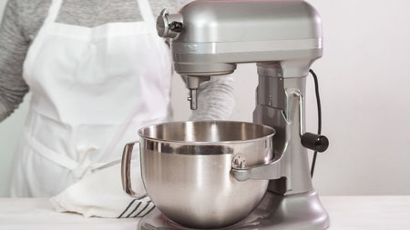 Step by step. Flat lay. Mixing royal icing in electric kitchen mixer for Easter cookies.