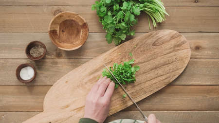 Flat lay. Cutting organic parsley on a wood cuttig board.の写真素材