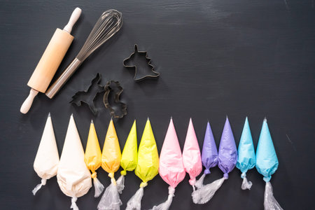 Flat lay. Variety of colors of royal icing in plastic piping bags.