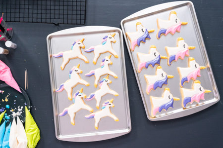 Flat lay. Decorating unicorn shaped sugar cookies with royal icing.の写真素材