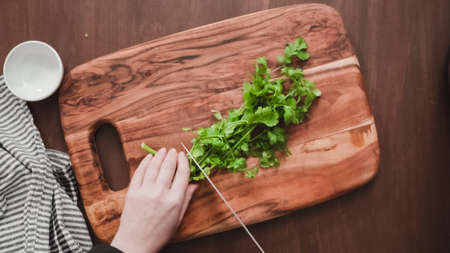 Step by step. Flat lay. Slicing fresh parsley to garnish beet soup, borscht.の写真素材