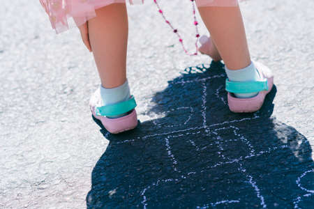 Little girl is playing hopscotch on sunny Spring daying suburbs.の写真素材