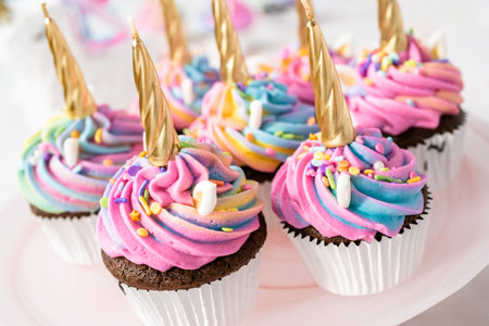 Unicorn cupcakes decorated with colorful buttercream icing and sprinkles.の写真素材