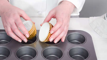 Step by step. Placing cupcake liners onto the cupcake pan to bake vanilla cupcakes.の写真素材