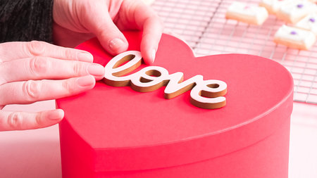 Packing heart shaped sugar cookies decorated with royal icing into the gift box.