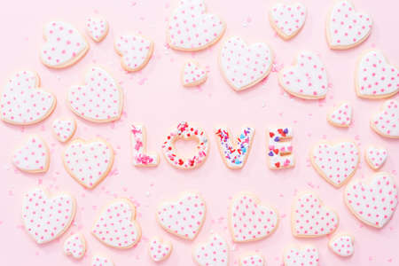 Flat lay. Sugar cookies decorated with royal icing on a pink background.の写真素材