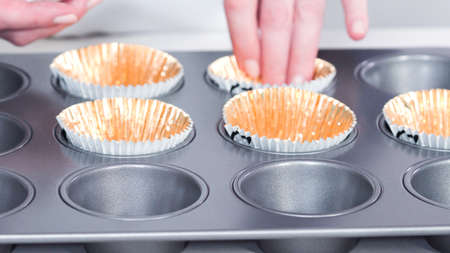 Step by step. Scooping batter with a cupcake scoop to make unicorn chocolate cupcakes with buttercream frosting.の写真素材