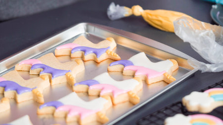 Step by step. Decorating unicorn sugar cookies with royal icing on baking sheet.の写真素材