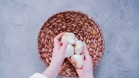 Flat lay. Organic garlic heads in wicker basket.の写真素材