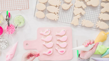 Step by step. Flat lay. Decorating Easter sugar cookies with rotal icing.