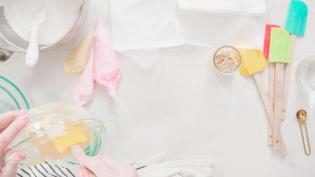 Step by step. Flat lay. Mixing royal icing to decorate Easter sugar cookeis.の写真素材