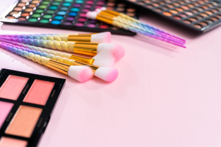New eyeshadow palette with makeup brushes on a pink background.の写真素材