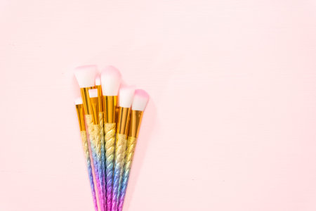 Flat lay. Unicorn color makeup brushes on a pink background.の写真素材