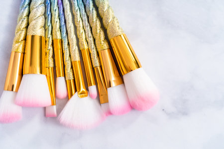 Unicorn color makeup brushes on a marble background.