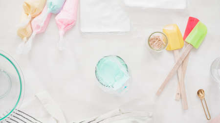 Step by step. Flat lay. Mixing royal icing to decorate Easter sugar cookeis.の写真素材