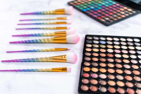 New eyeshadow palette with makeup brushes on marble background.の写真素材