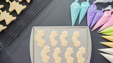 Flat lay. Decorating unicorn sugar cookies with multi-color royal icing.