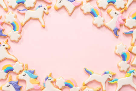 Flat lay. unicorn sugar cookies decorated with royal icing and food glitter on a pink background.の写真素材