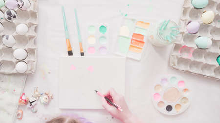 Little girl and her mom painting Easter art project with acrylic paint.の写真素材