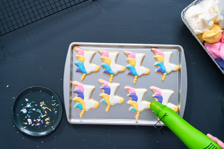 Flat lay. Decorating unicorn sugar cookies with royal icing.