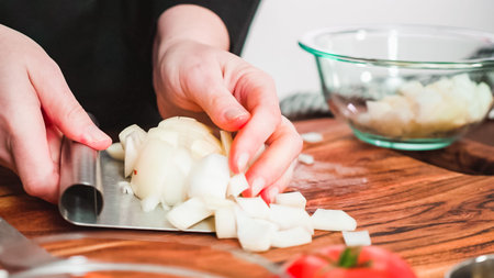 Step by step. Slicing yellow onion into the small cubes for beet soup, borscht.