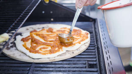 Cooking pizza on outdoor gas grill.の写真素材